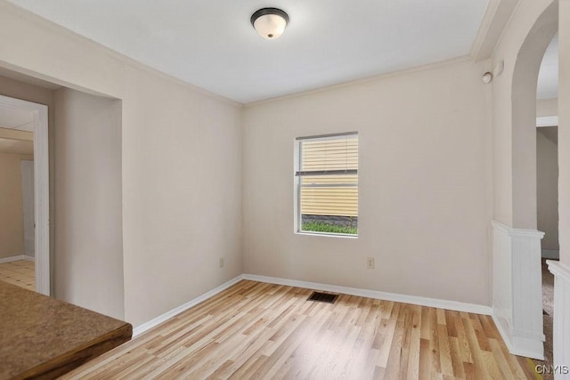 6 E 6th St, Oswego-City, NY 13126 - spare room featuring light wood finished floors, ornamental molding, arched walkways, and baseboards