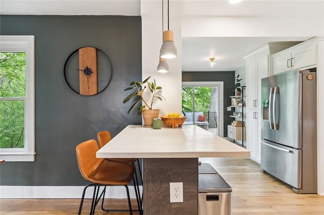 314 Hamilton St, Benton, NY 14527 - kitchen with stainless steel refrigerator with ice dispenser, white cabinetry, a kitchen breakfast bar, and light wood-style flooring