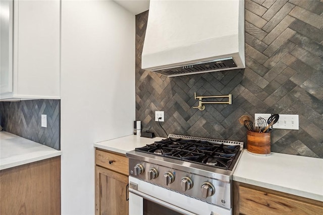 314 Hamilton St, Benton, NY 14527 - kitchen featuring stainless steel gas range oven, decorative backsplash, premium range hood, and light countertops
