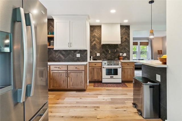 314 Hamilton St, Benton, NY 14527 - kitchen featuring stainless steel appliances, wall chimney range hood, light countertops, light wood finished floors, and decorative backsplash