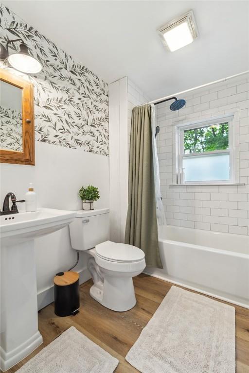 314 Hamilton St, Benton, NY 14527 - full bath featuring toilet, wood finished floors, and shower / tub combo with curtain