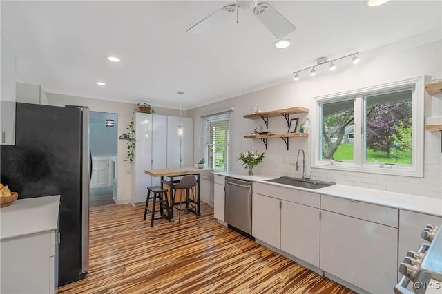 9 Bishop Dr, Manlius, NY 13066 - kitchen with appliances with stainless steel finishes, a sink, wood finished floors, backsplash, and a ceiling fan