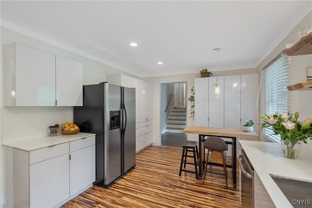 9 Bishop Dr, Manlius, NY 13066 - kitchen featuring appliances with stainless steel finishes, white cabinets, light wood-type flooring, light countertops, and ornamental molding