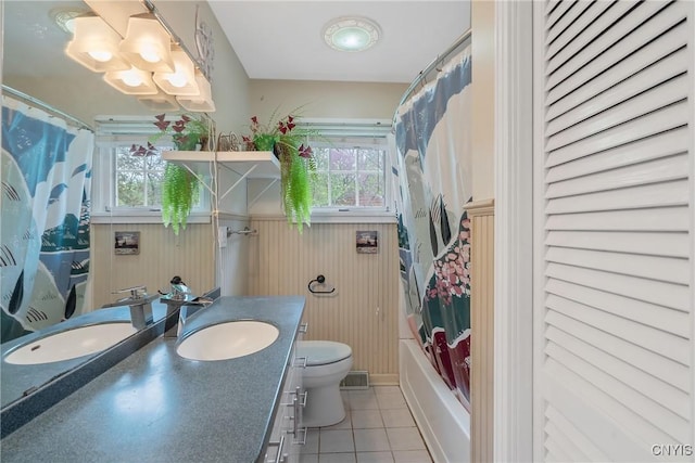 9 Bishop Dr, Manlius, NY 13066 - bathroom with tile patterned floors, vanity, plenty of natural light, toilet, and wainscoting