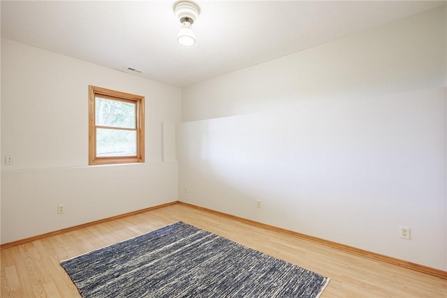 spare room featuring light wood finished floors and baseboards