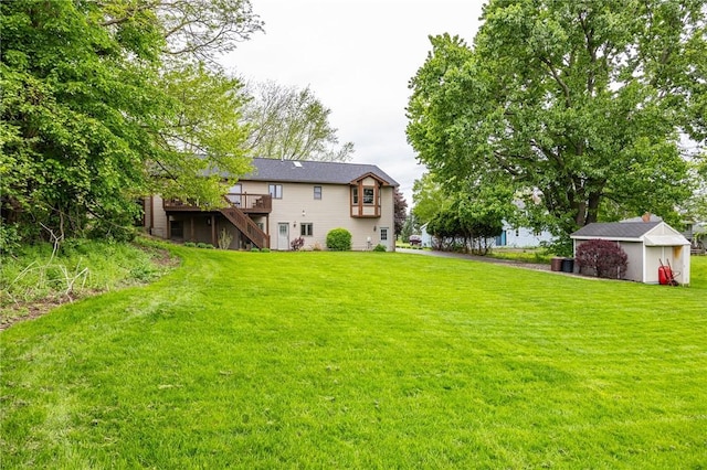 view of grassy yard featuring stairs, a deck, an outbuilding, and a shed