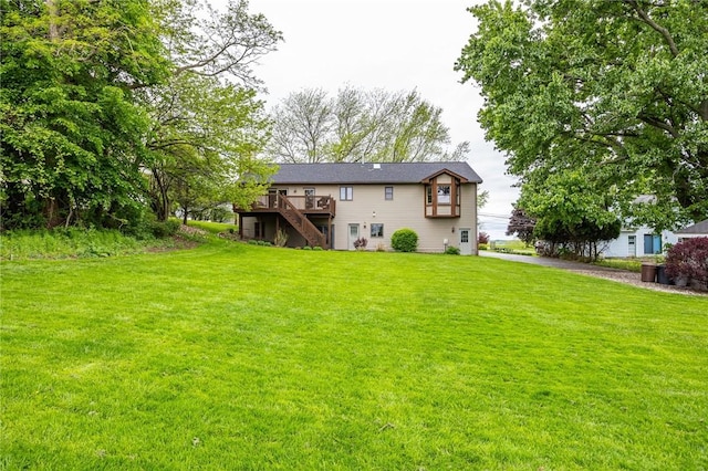 rear view of house with stairs, a deck, and a lawn