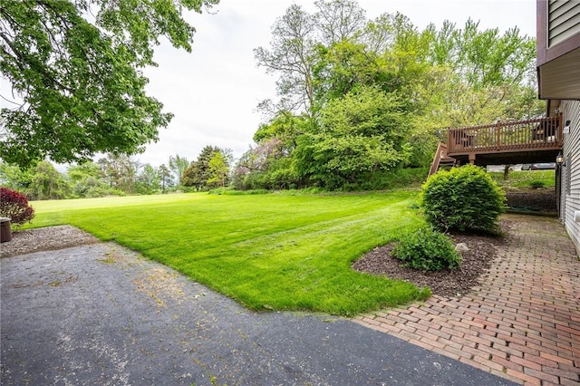 view of green lawn with a deck