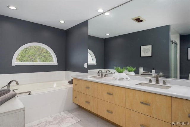 full bathroom featuring a garden tub, double vanity, tile patterned floors, and recessed lighting
