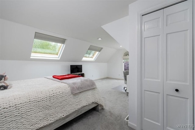 carpeted bedroom featuring a skylight, vaulted ceiling, recessed lighting, and baseboards