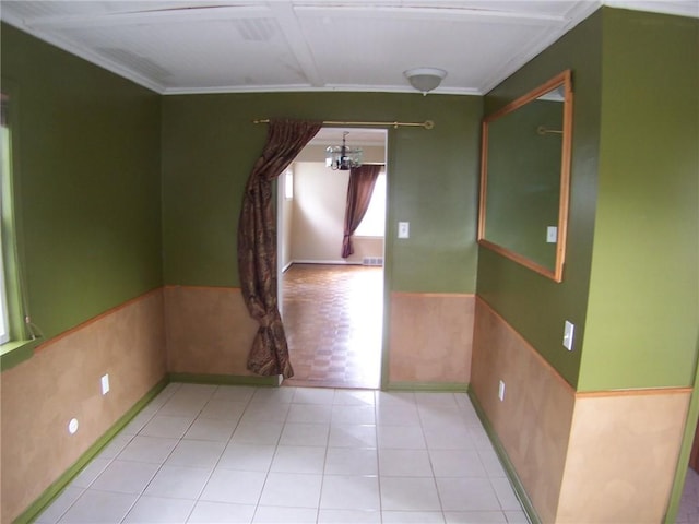 unfurnished room featuring a chandelier, wainscoting, ornamental molding, and baseboards
