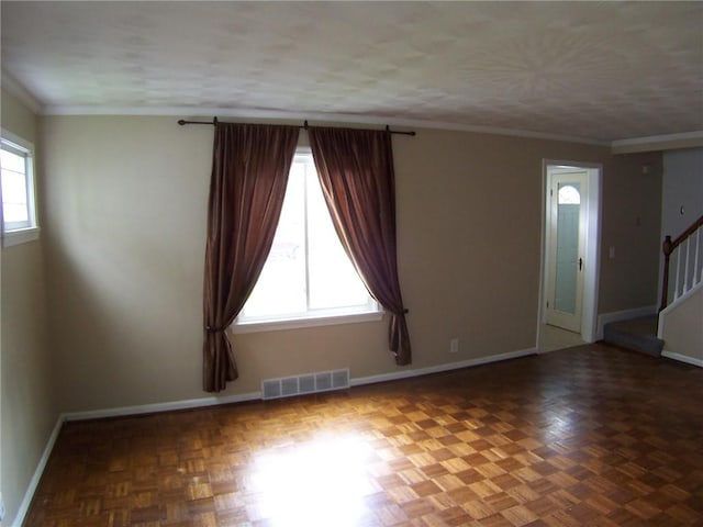 empty room featuring stairway, baseboards, and ornamental molding