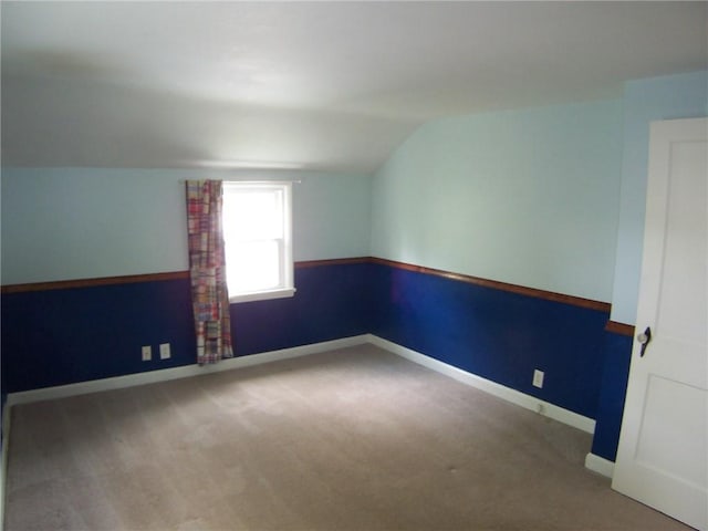 bonus room featuring lofted ceiling, carpet floors, and baseboards