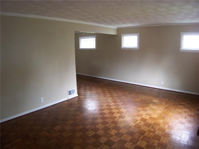 unfurnished room featuring ornamental molding, baseboards, and plenty of natural light