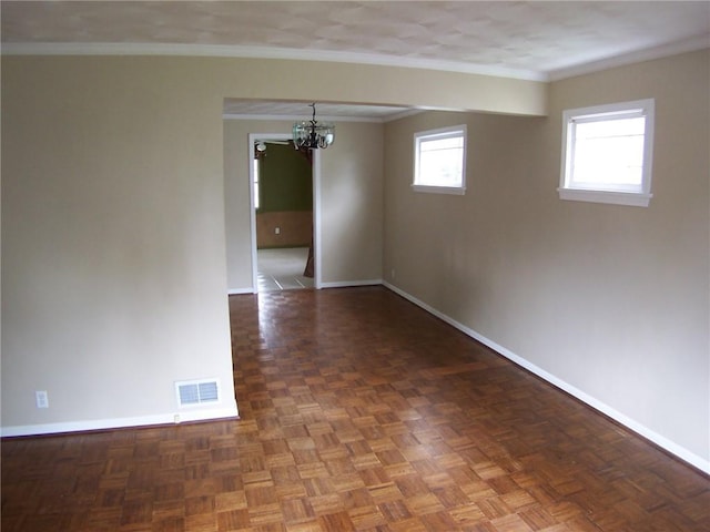 unfurnished room featuring baseboards, a chandelier, and crown molding