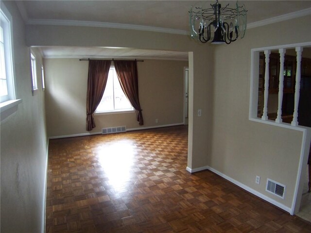 empty room featuring baseboards, a chandelier, and ornamental molding