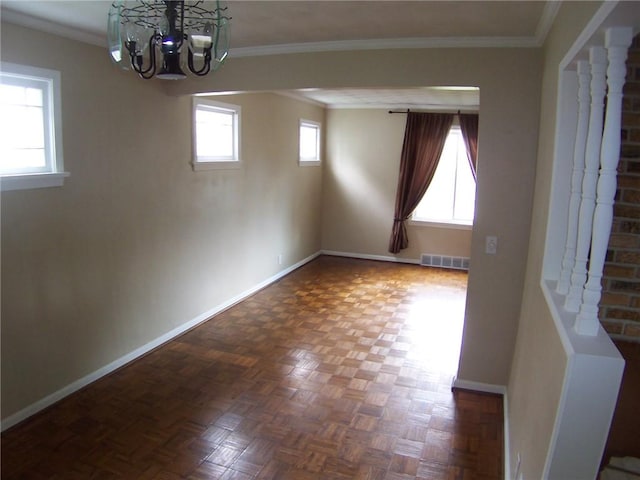 empty room featuring a chandelier, baseboards, and ornamental molding