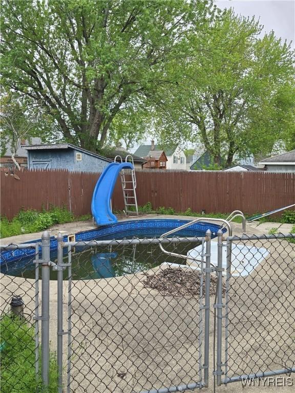 56 Gibbons St, Lackawanna, NY 14218 - view of swimming pool with a water slide, a fenced backyard, and a gate