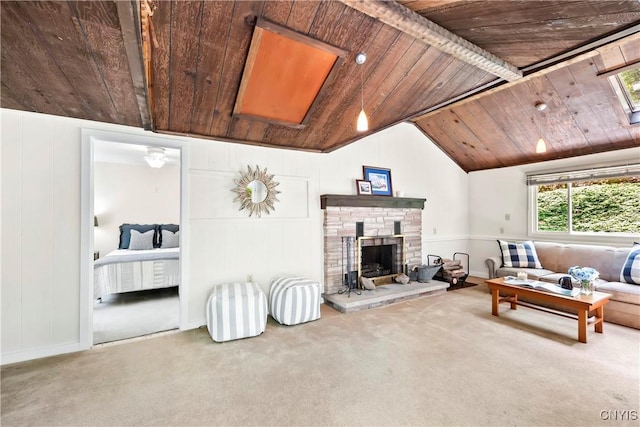 living area with wooden ceiling, carpet, and a stone fireplace
