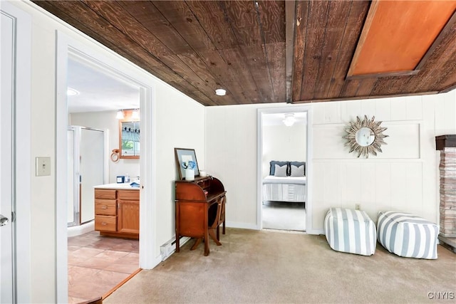 living area featuring wooden ceiling, light colored carpet, and baseboards