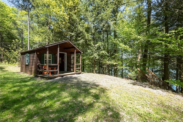 view of outbuilding featuring a wooded view and an outbuilding