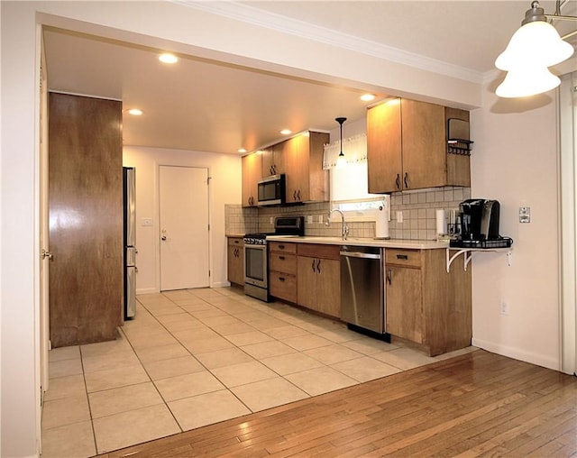31 Jefreelind Dr, Greece, NY 14616 - kitchen featuring stainless steel appliances, backsplash, brown cabinetry, ornamental molding, and light wood-style floors