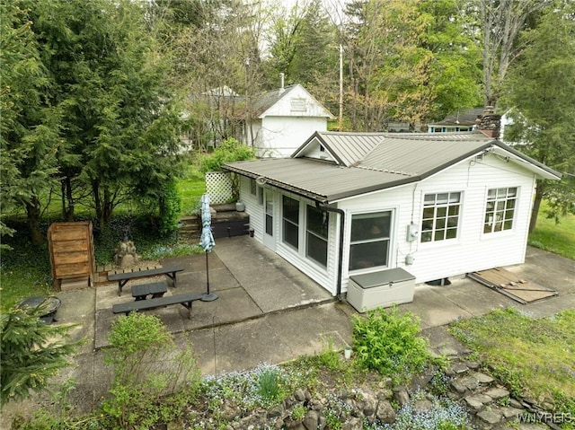 back of property with a patio area and metal roof