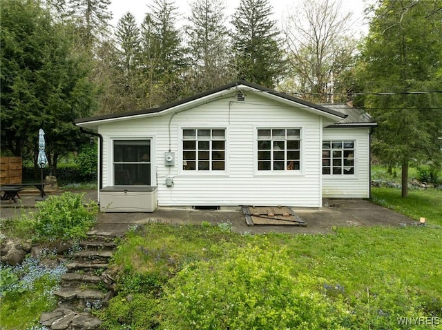 back of house with a lawn and a patio area
