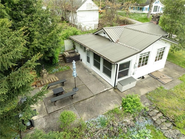 back of house with a patio area and metal roof