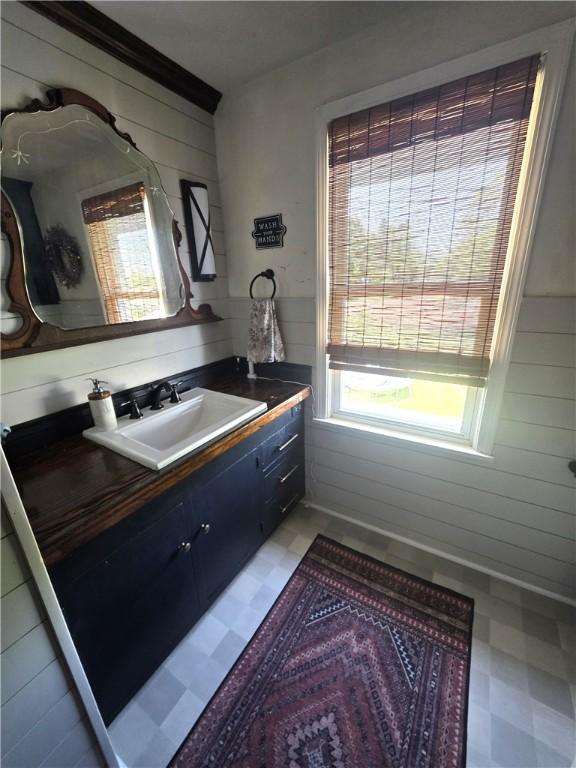 119 Verona St, Elmira, NY 14903 - bathroom featuring tile patterned floors, wood walls, and vanity