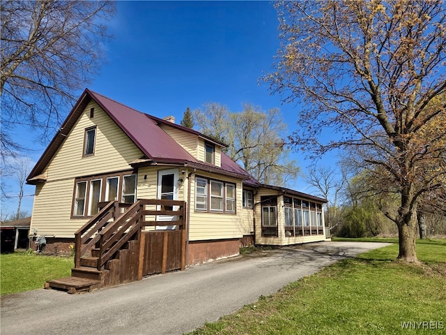 11343 Slade Rd, Ridgeway, NY 14103 - view of front of house with a front yard, metal roof, and driveway
