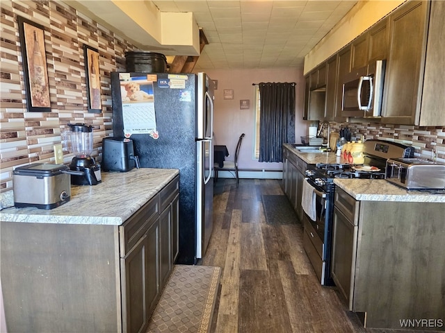 11343 Slade Rd, Ridgeway, NY 14103 - kitchen with appliances with stainless steel finishes, a sink, dark wood finished floors, a baseboard heating unit, and backsplash