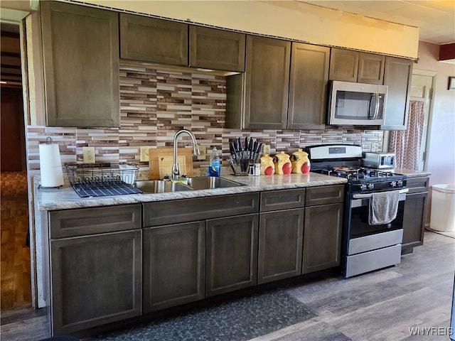 11343 Slade Rd, Ridgeway, NY 14103 - kitchen with stainless steel appliances, a sink, light wood-style floors, and decorative backsplash