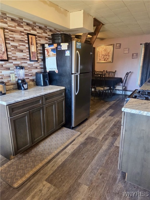 11343 Slade Rd, Ridgeway, NY 14103 - kitchen featuring dark wood-style flooring, light countertops, dark brown cabinetry, and freestanding refrigerator