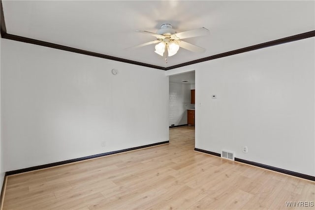 spare room featuring a ceiling fan, ornamental molding, baseboards, and light wood-type flooring
