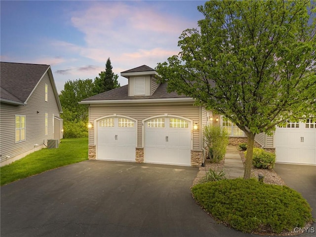 119 Star Gaze Cir, Manlius, NY 13066 - view of front of home with stone siding, asphalt driveway, an attached garage, central AC unit, and a shingled roof