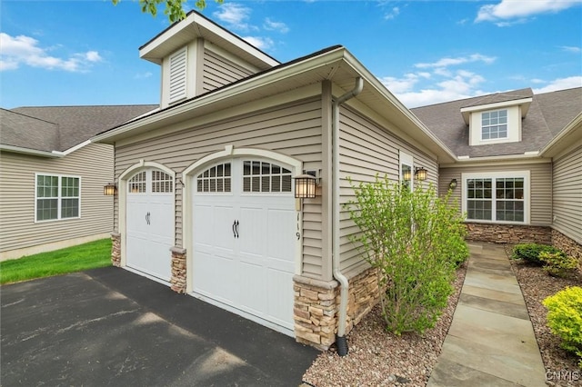 119 Star Gaze Cir, Manlius, NY 13066 - view of property exterior featuring stone siding, driveway, an attached garage, and roof with shingles