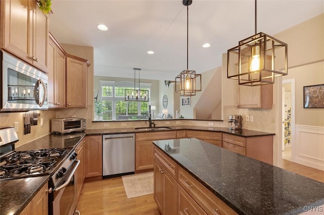 119 Star Gaze Cir, Manlius, NY 13066 - kitchen with stainless steel appliances, light wood-type flooring, a sink, backsplash, and a wainscoted wall