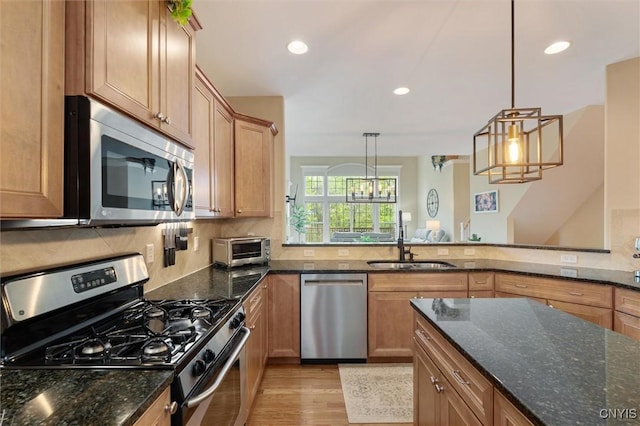 119 Star Gaze Cir, Manlius, NY 13066 - kitchen with appliances with stainless steel finishes, a sink, light wood-type flooring, decorative backsplash, and dark stone countertops