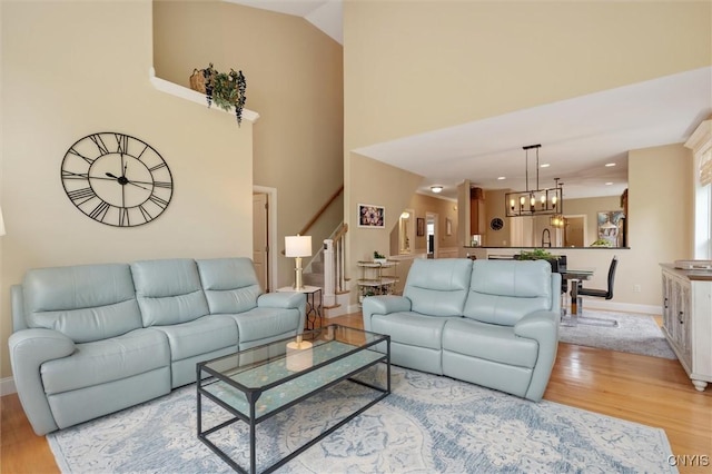 119 Star Gaze Cir, Manlius, NY 13066 - living room with stairs, light wood-style floors, a chandelier, baseboards, and recessed lighting