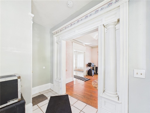 entryway featuring light tile patterned flooring, baseboards, ornate columns, and heating unit