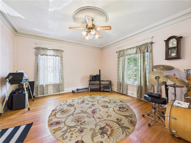 office space with wood finished floors, crown molding, and a ceiling fan