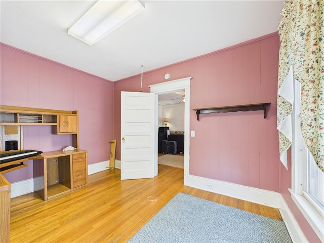 kitchen with light wood-style flooring, baseboards, and lofted ceiling