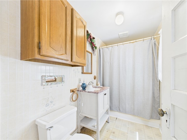 bathroom with toilet, curtained shower, vanity, and tile patterned floors