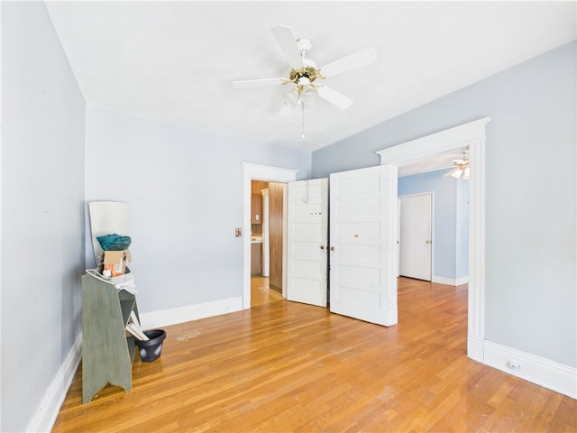 unfurnished bedroom featuring baseboards, light wood-style flooring, and a ceiling fan