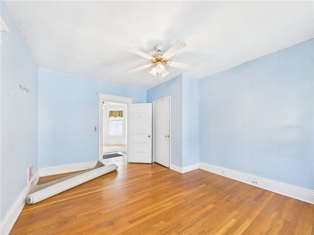 unfurnished bedroom with baseboards, light wood-style flooring, and ceiling fan