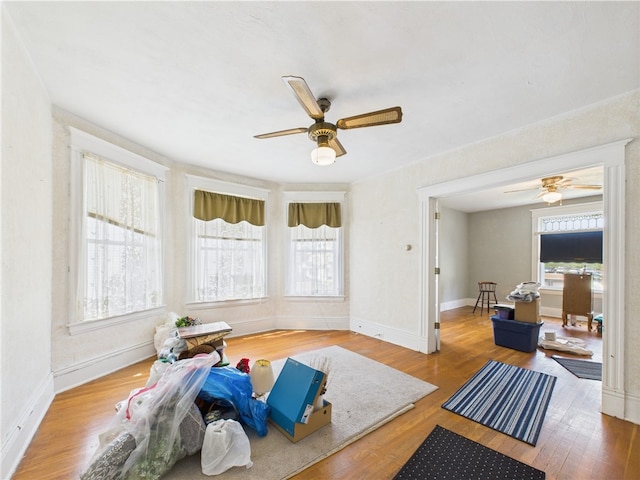 living room with ceiling fan, wood finished floors, and baseboards