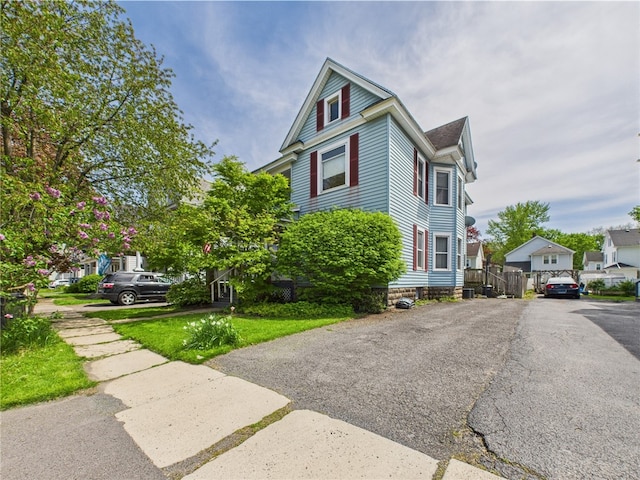 view of front of home featuring asphalt driveway and a residential view