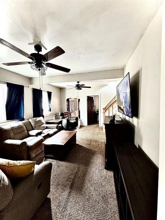 426 Loder St, Barton, NY 14892 - carpeted living area featuring a ceiling fan, healthy amount of natural light, a textured ceiling, and stairs