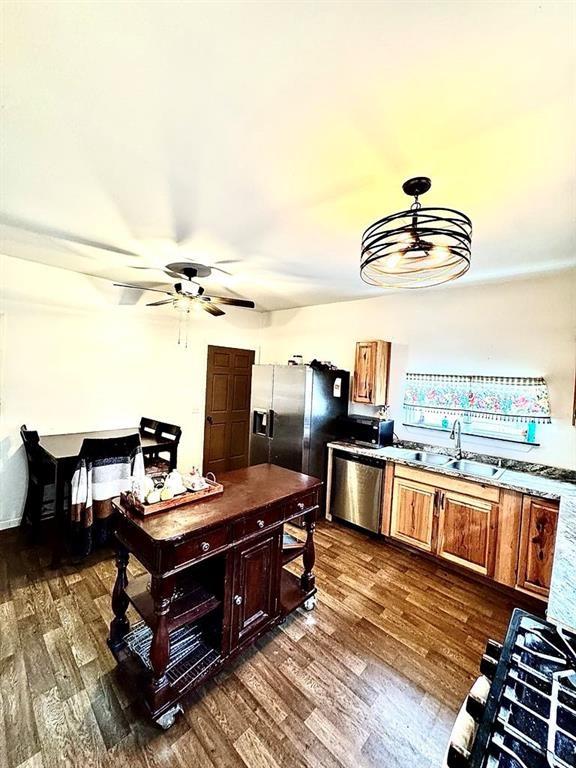 426 Loder St, Barton, NY 14892 - kitchen with appliances with stainless steel finishes, a ceiling fan, dark wood-style flooring, a sink, and brown cabinets